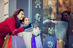 Mother and daughter are looking shop window